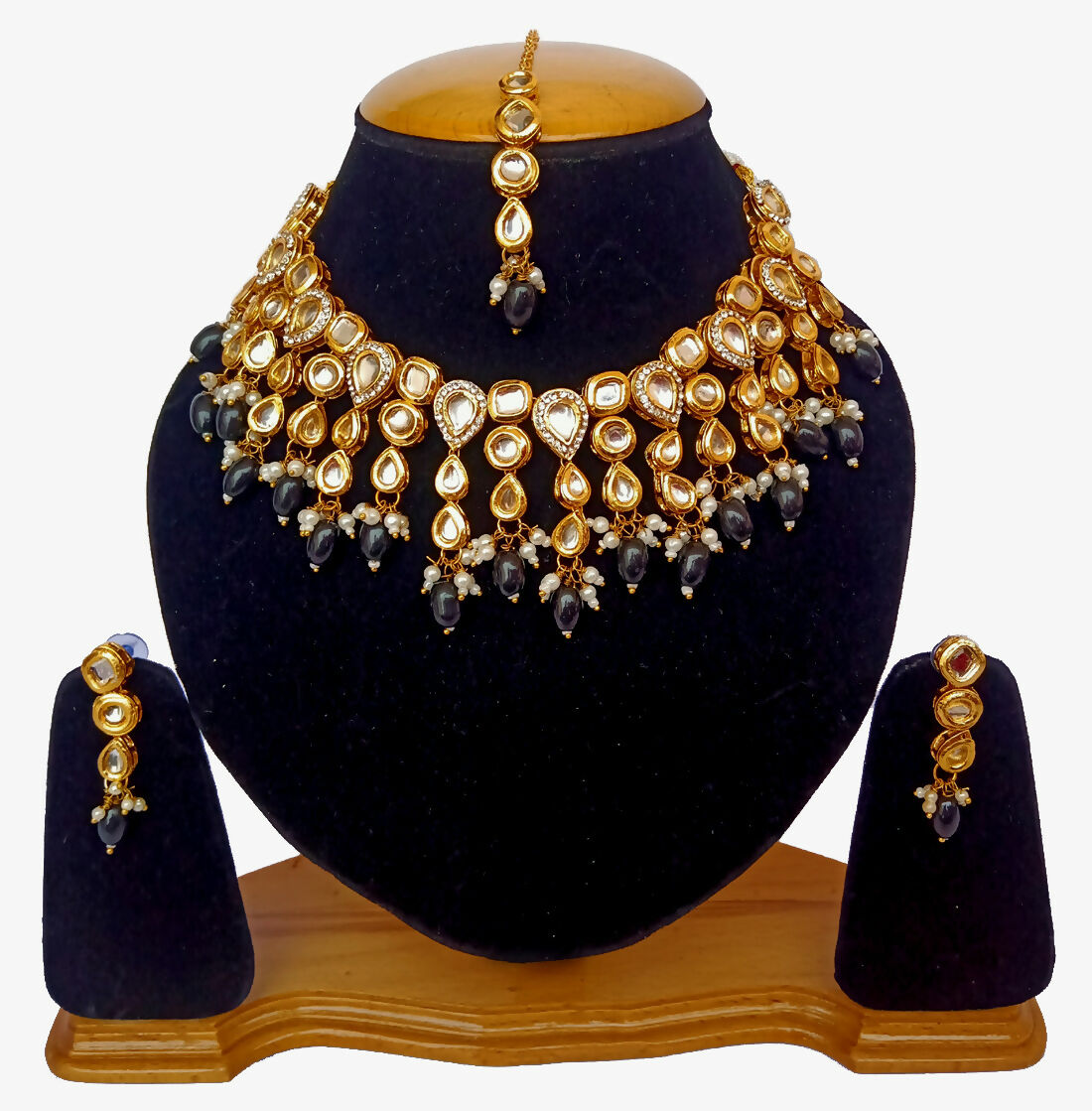 Gold plated Kundan necklace set with intricate stone work on a decorative background