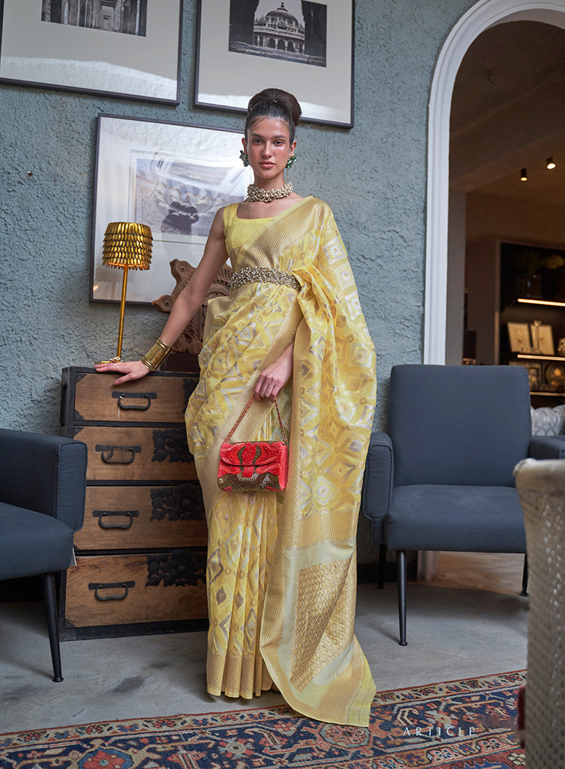 Elegant light yellow linen saree with woven zari border and matching blouse piece.