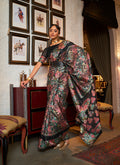 Classic black silk saree with a decorative printed border and motifs.