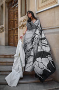 Model wearing a stylish grey and black printed satin saree with a smooth finish