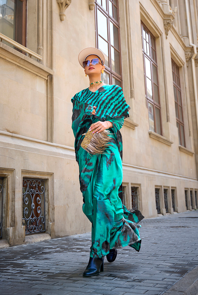 Elegant teal printed satin saree featuring a vibrant pattern and smooth drape
