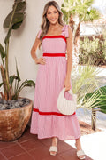 A woman wearing a red and white striped midi dress with bow-tie straps and a ruffle hem, in an A-line silhouette.