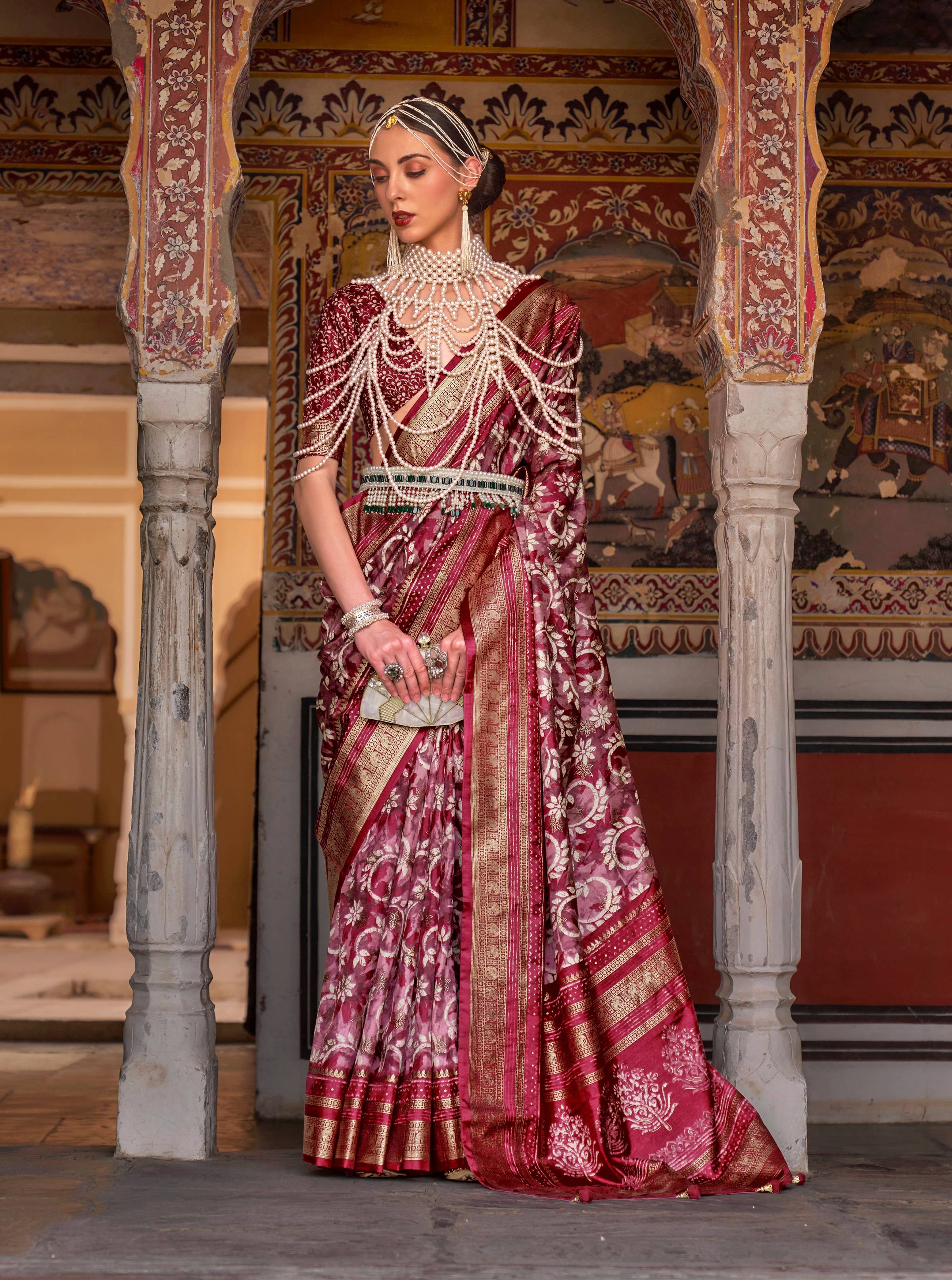 A vibrant red silk saree adorned with classic Ajarak prints and detailed zari work.