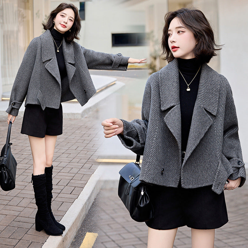 Model wearing a stylish cropped double-sided woolen coat in grey, paired with a black turtleneck and shorts, demonstrating a versatile winter outfit.