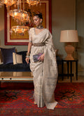 Elegant cream-colored silk saree adorned with intricate ethnic weaving work
