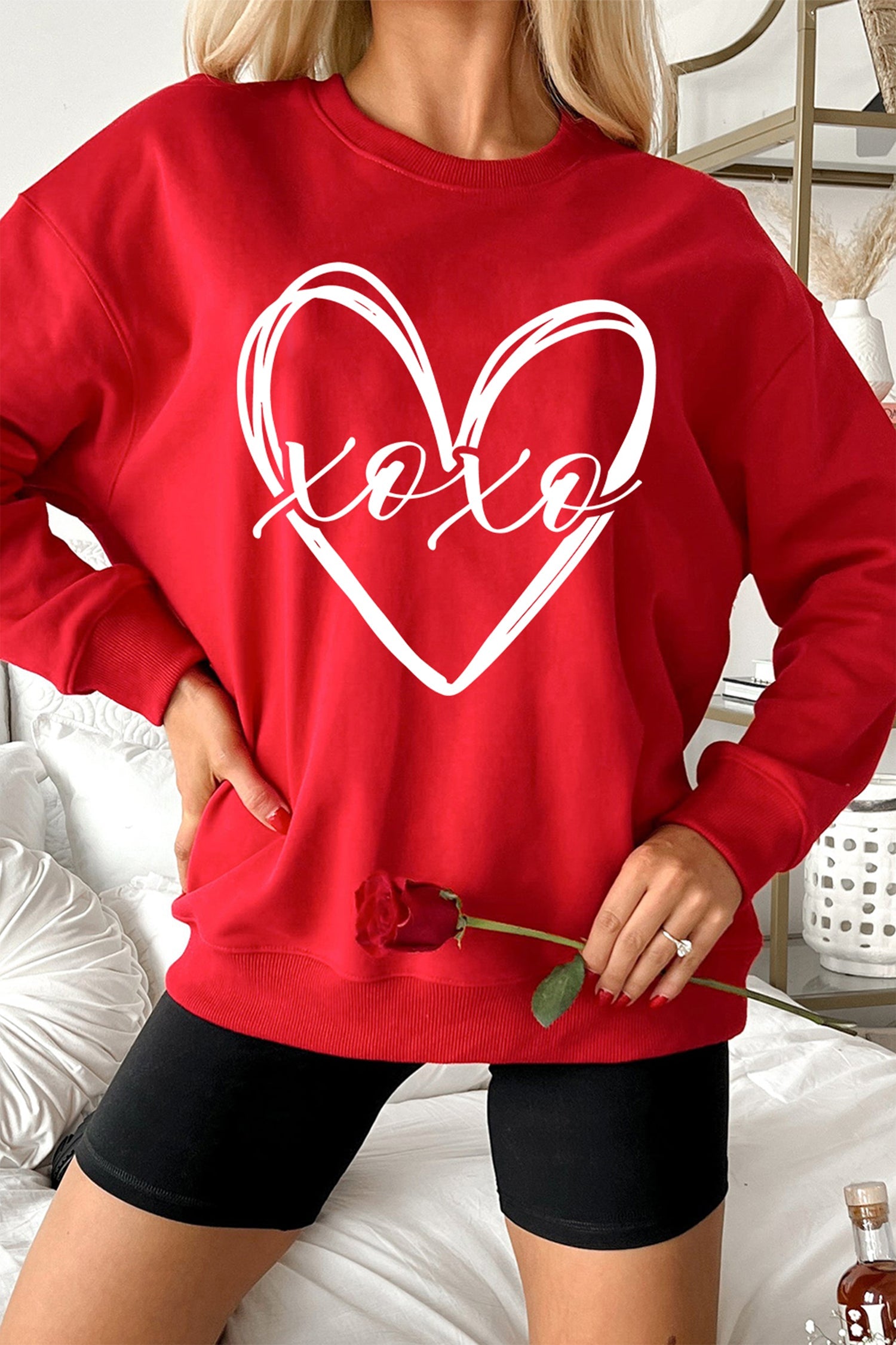Red pullover sweatshirt with XOXO lettering and cursive heart sketch print