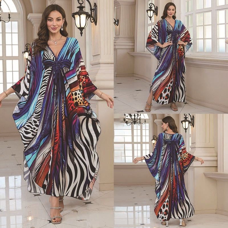 A woman wearing a vibrant printed bohemian V-neck maxi kaftan dress on a beach.
