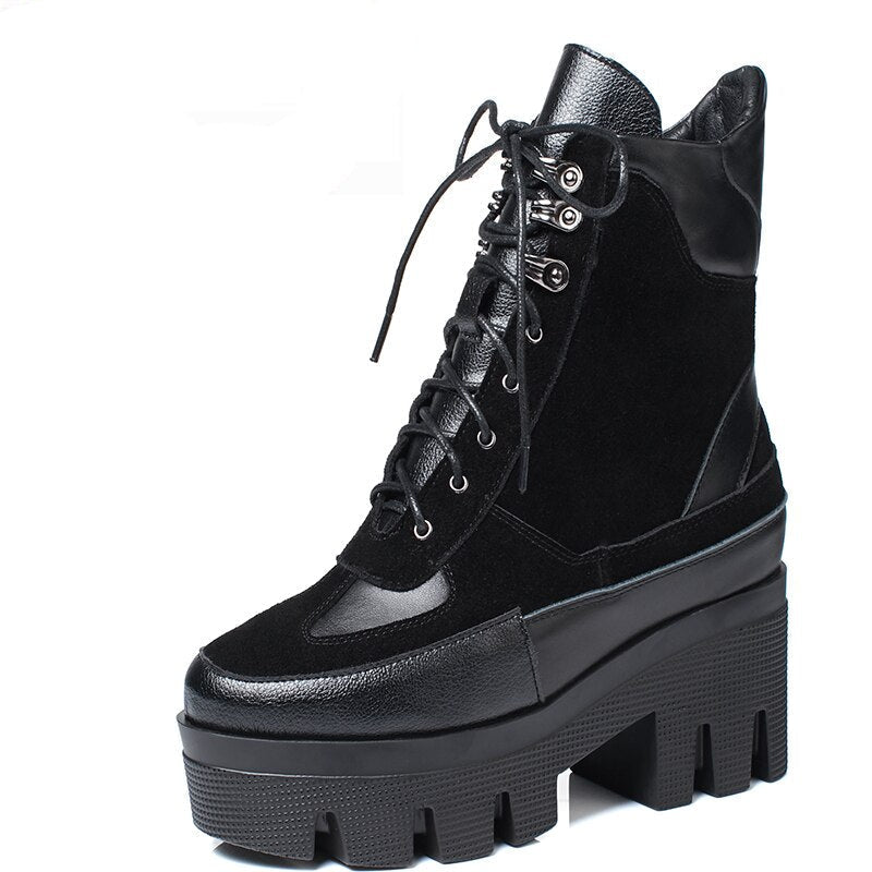 A pair of black cow leather chunky platform ankle boots with lace-up fronts and a rugged sole, displayed on a white background.