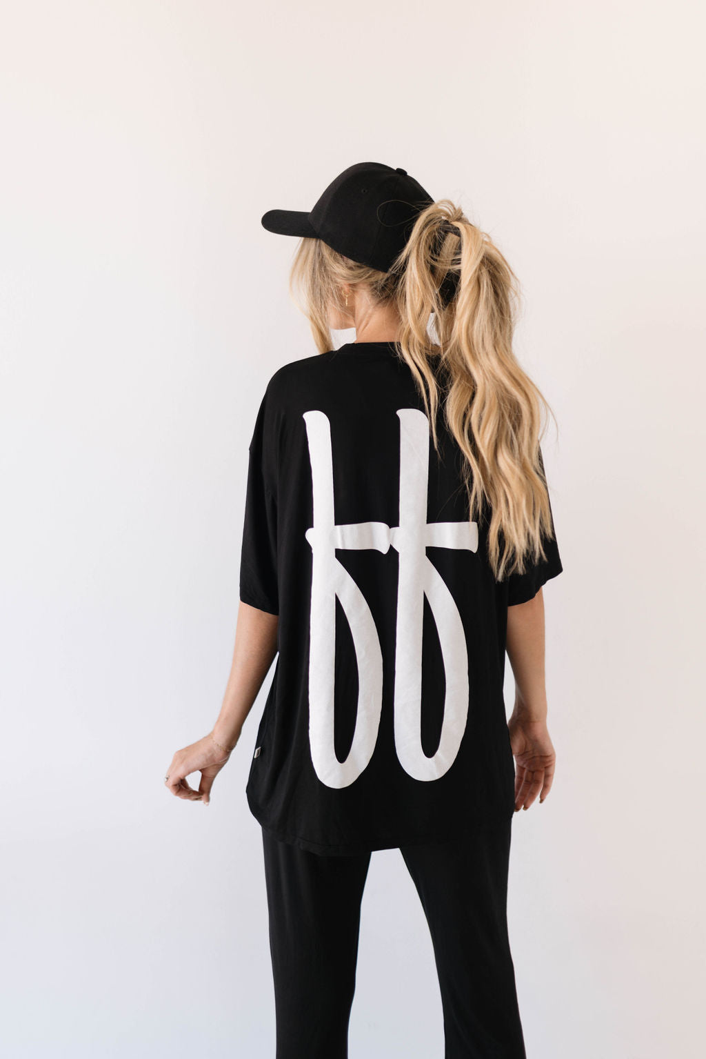 Woman wearing a black short sleeve bamboo lounge set with a relaxed fit tee and slightly flared pants.