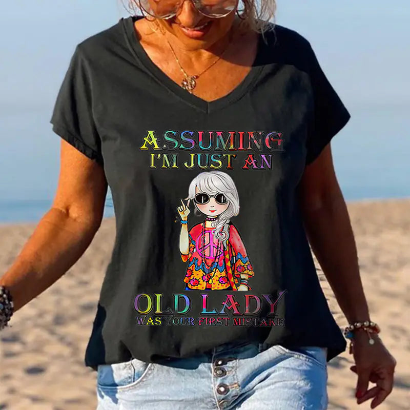 Woman wearing a black V-neck t-shirt with a graphic design print on the beach