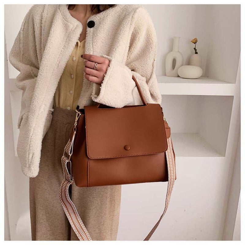 A simple leather crossbody messenger bag for girls in a modern, elegant style.
