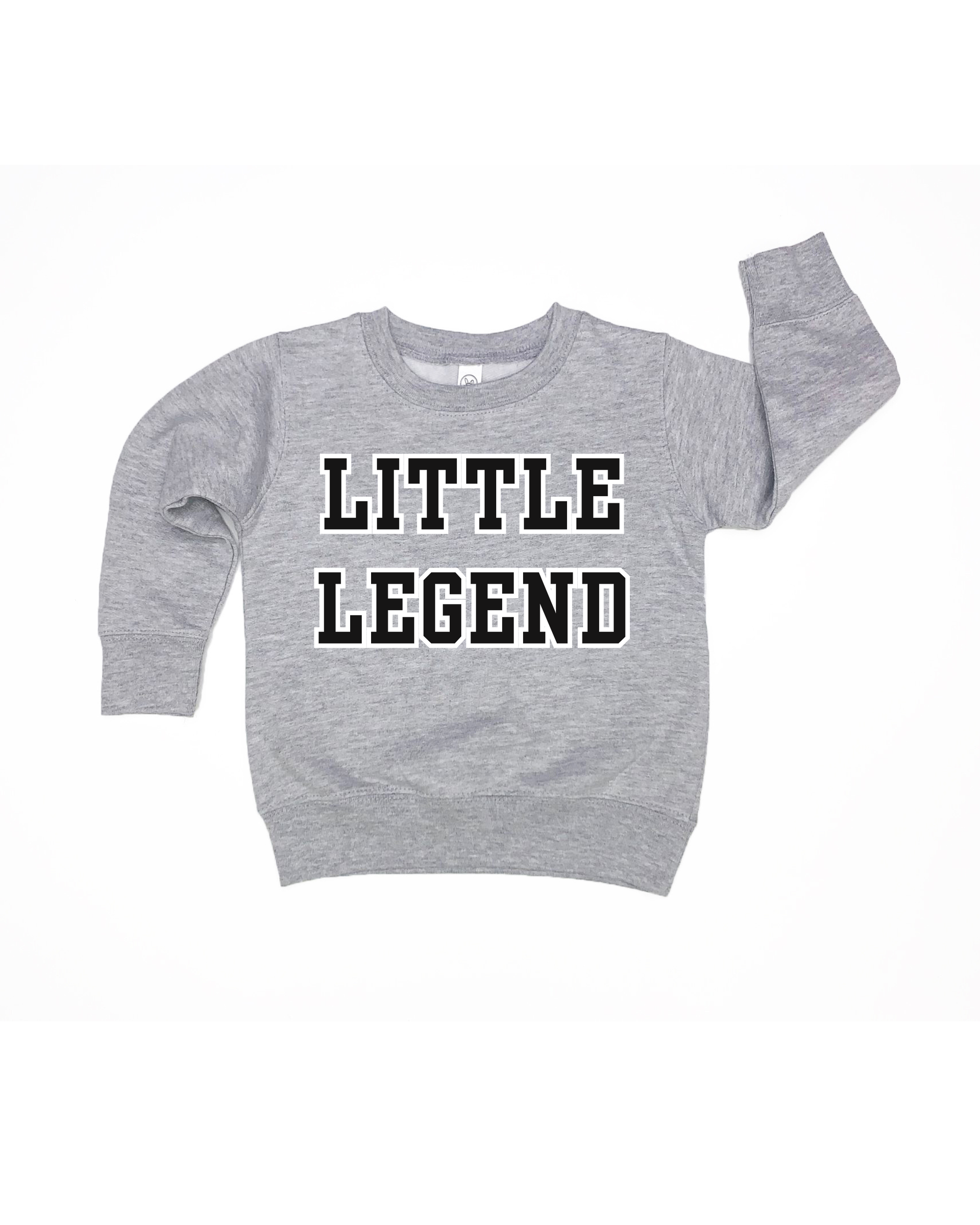 Kids wearing a solid knit varsity pullover in grey, black, and cream.