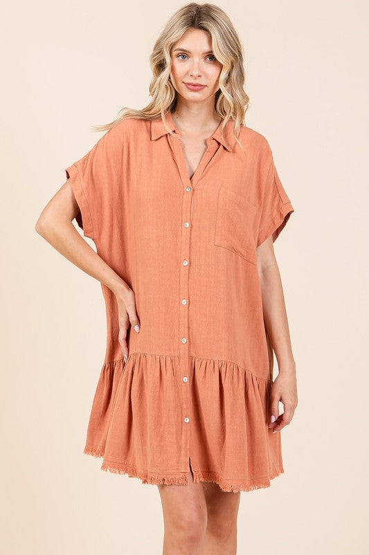 Woman wearing a linen blend button down shirt mini dress with tiered detailing and a raw hem