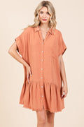 Woman wearing a linen blend button down shirt mini dress with tiered detailing and a raw hem