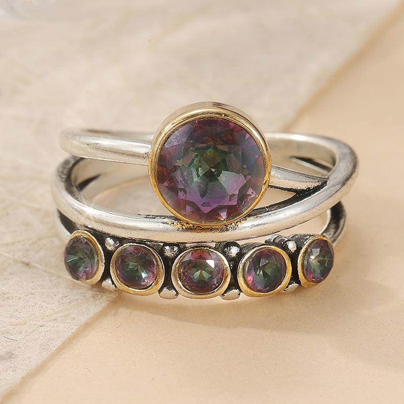 Bohemian-style multi-band stackable ring with iridescent cubic zirconia stones and polished finish.