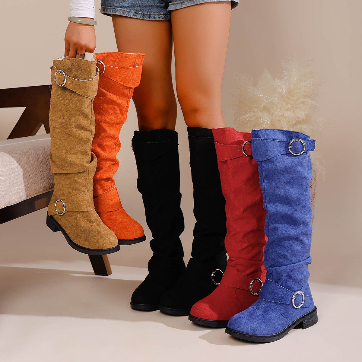 A selection of colorful flat-bottom western cowboy boots with pleated shafts and silver belt buckle details.