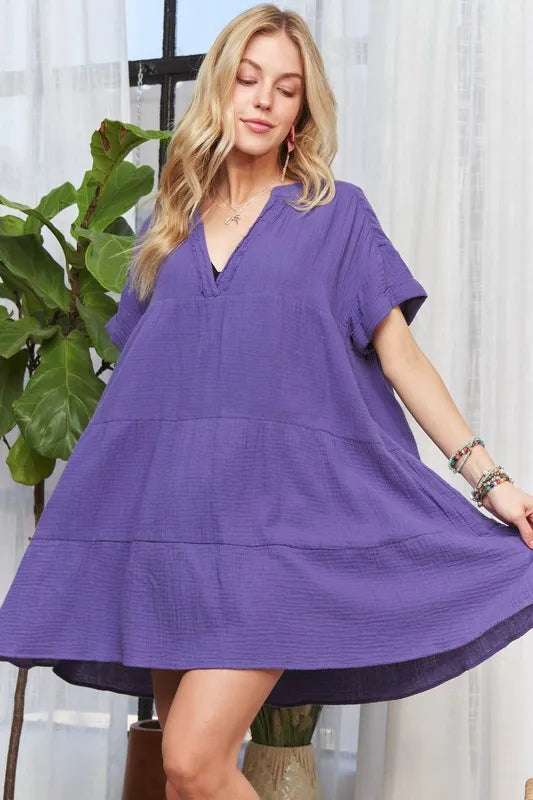 Purple tiered cotton dress with a notched neckline and short sleeves.