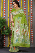 Classic green Banarasi silk saree with detailed Zari weaving and a matching green blouse piece.