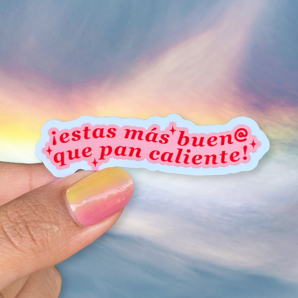 Sticker with Spanish text held by a hand against a colorful background