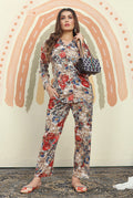 Woman wearing a beige, red, and blue floral print rayon co-ord set with collared long-sleeve top and matching pants.