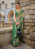 A green silk saree featuring a geometric border pattern and matching blouse piece.