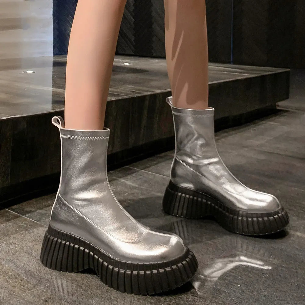 A person wearing metallic silver platform stretch ankle boots with a chunky black ridged sole. A second image shows a black denim platform ankle boot with the same sole, highlighting the 6cm heel height.