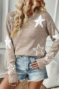 A woman wearing a tan pullover sweater with a white star pattern, crew neckline, and ribbed cuffs.