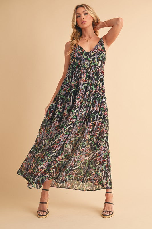 A woman wearing a playful printed V-neck cami dress with frill tiered details in a summer setting.
