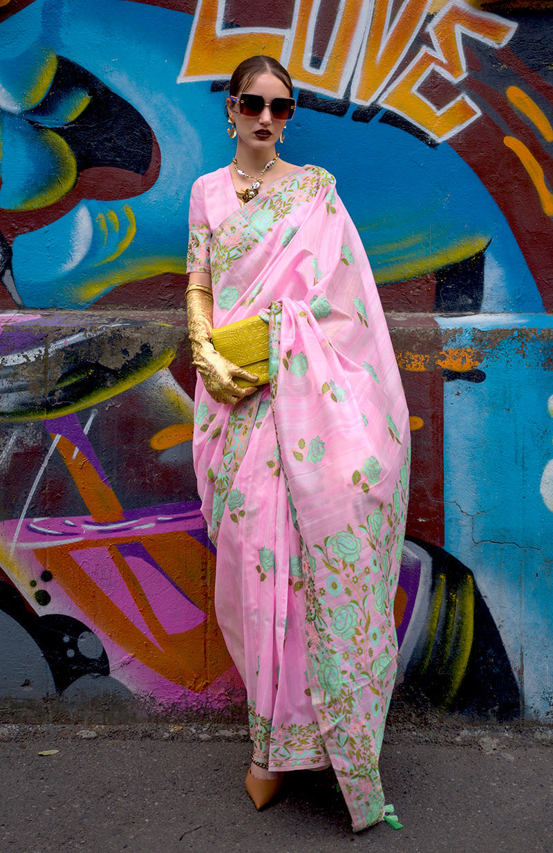 A beautiful pink handloom silk ethnic saree with intricate weaving patterns.