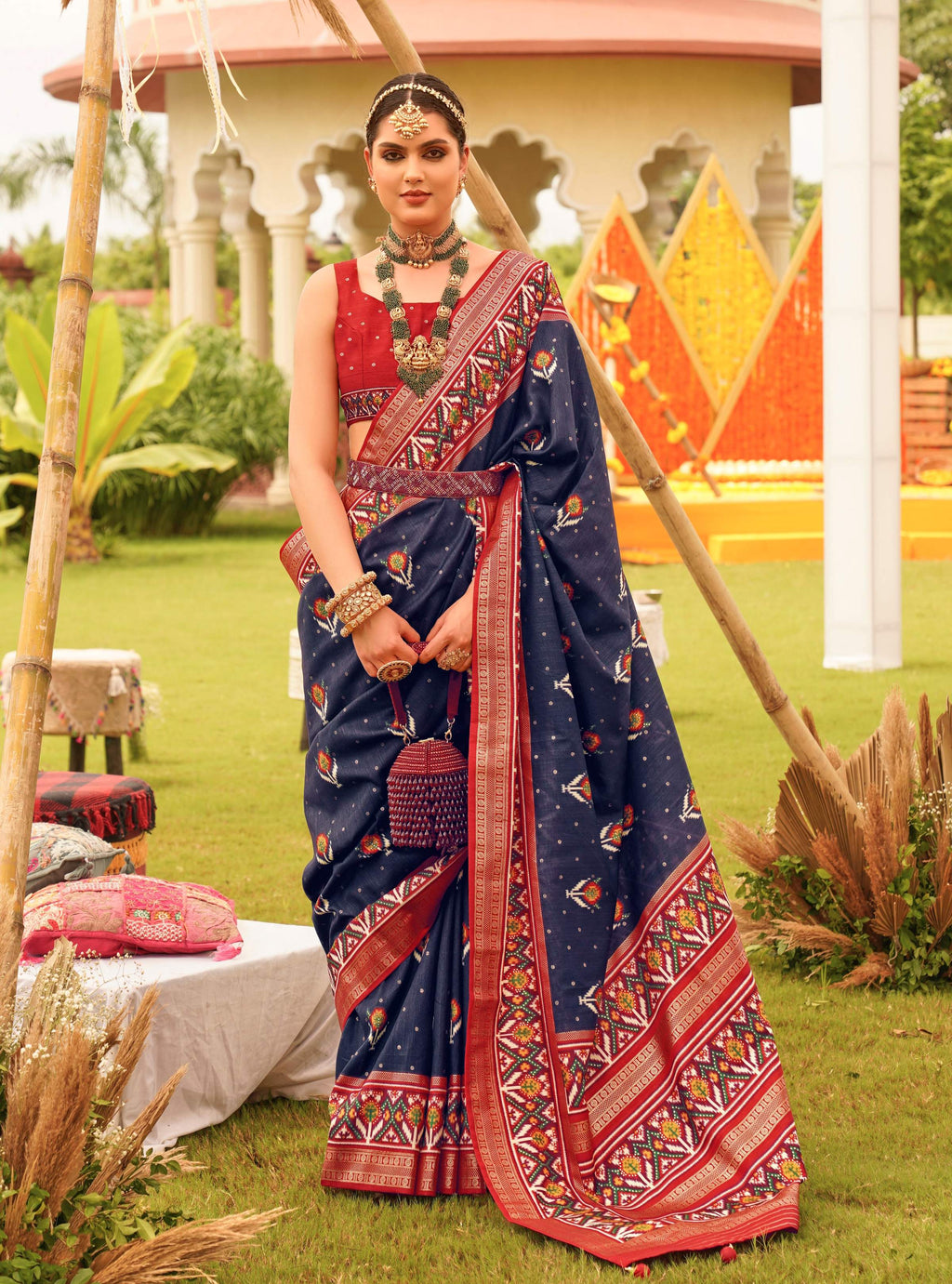 A sophisticated Navy Blue Sigma Silk saree with traditional Patola print and matching blouse piece.