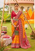 Amber and maroon Patola printed silk saree with traditional geometric patterns and matching blouse.
