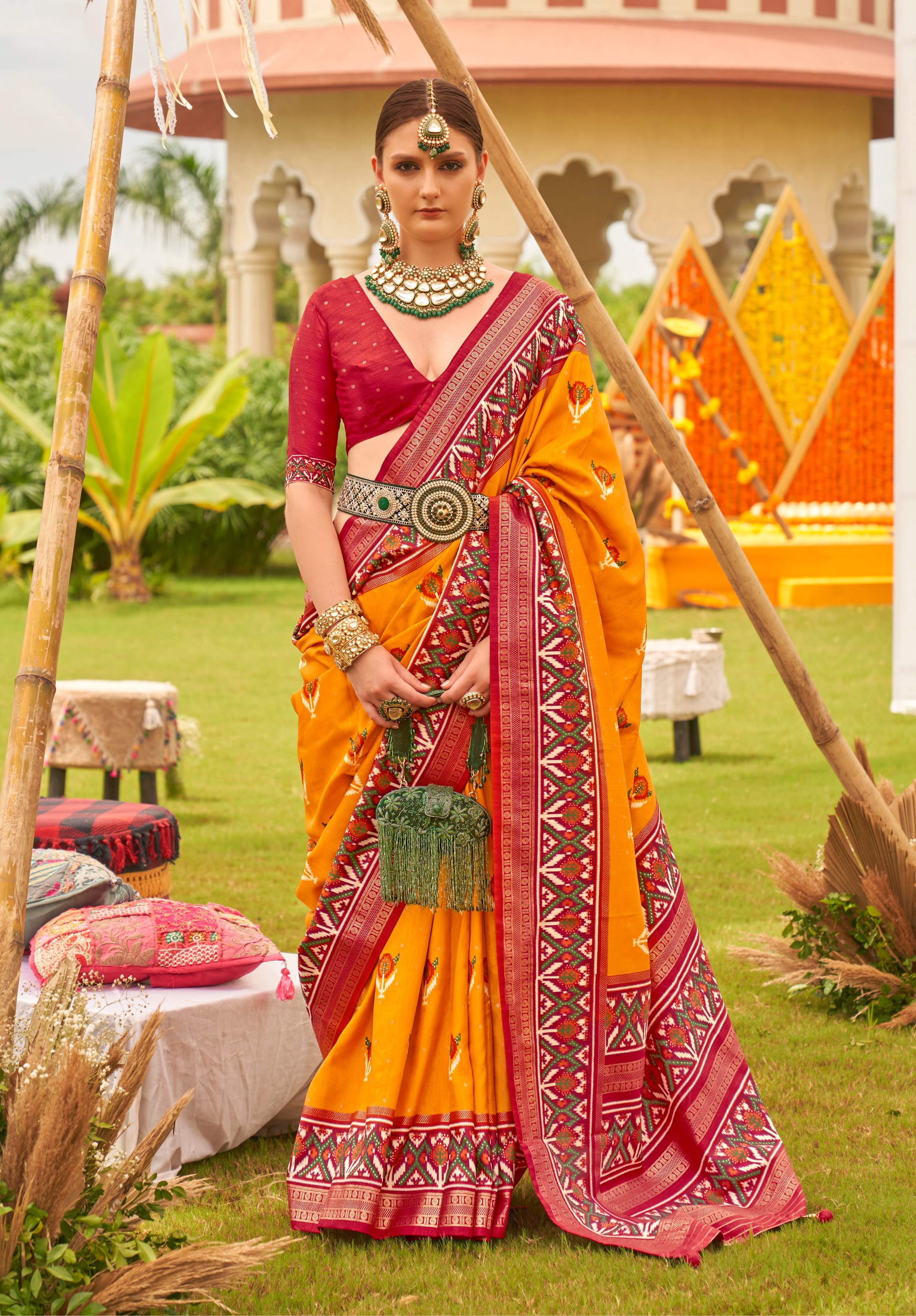 Amber and maroon Patola printed silk saree with traditional geometric patterns and matching blouse.