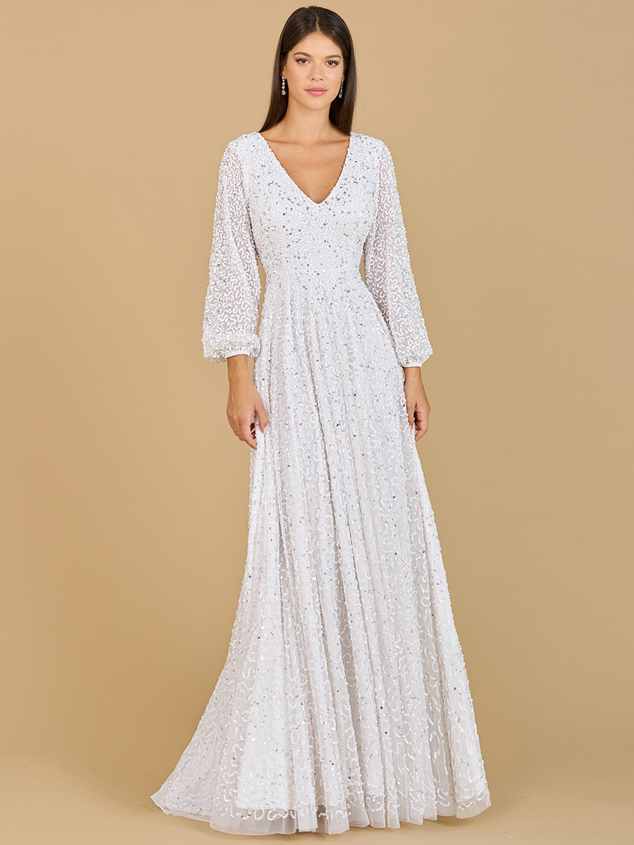 A bride wearing a white long-sleeved A-line gown with intricate beadwork and a low-back design.