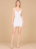 A model standing wearing a short white v-neck bridal reception dress with pearl and seed bead embellishments and fringe skirt details.