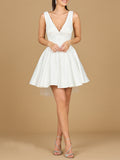 Model wearing a white satin v-neck mini bridal dress with a-line skirt and included veil