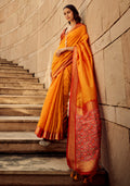 Orange colored handloom silk patola printed saree with matching blouse