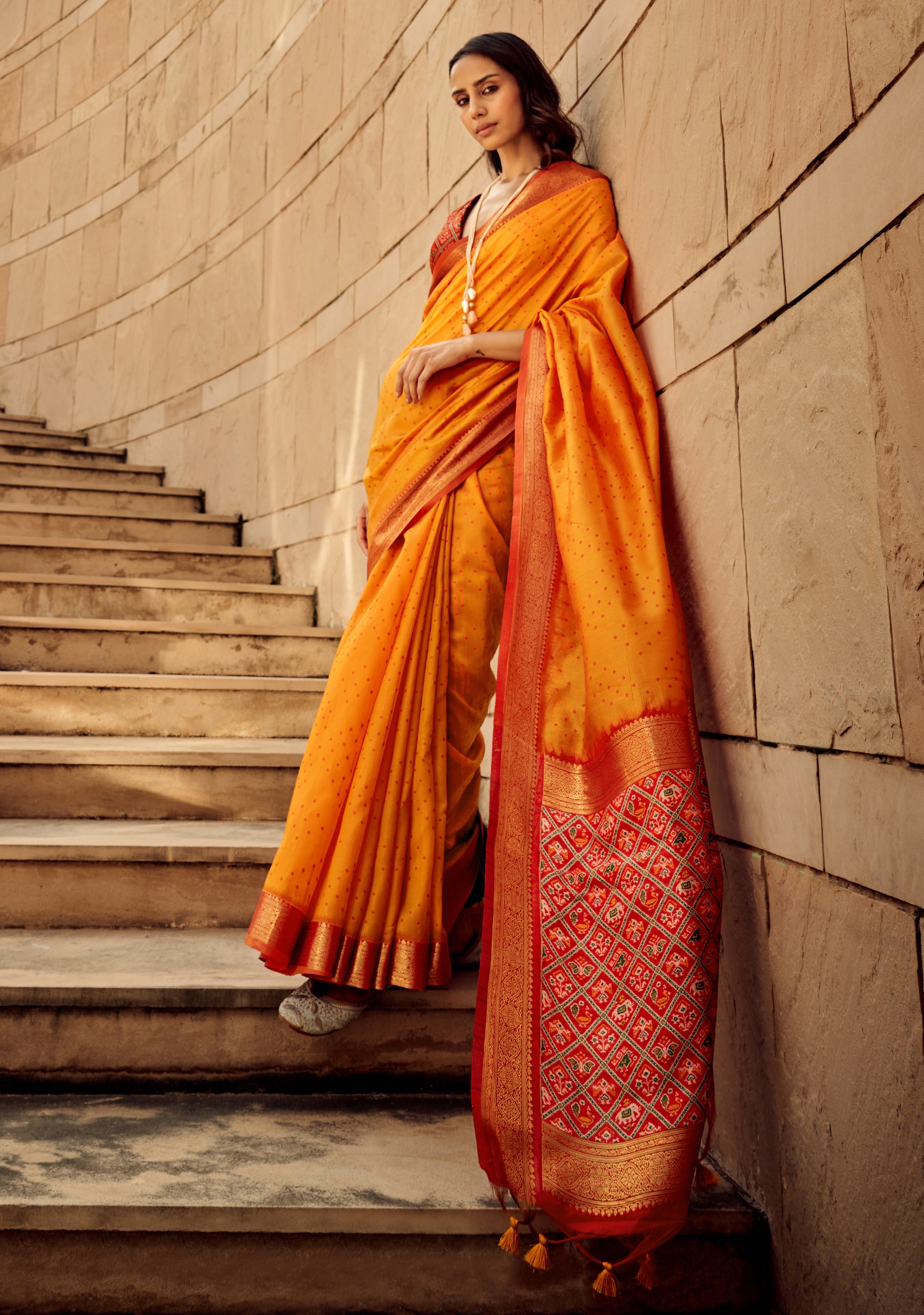 Orange colored handloom silk patola printed saree with matching blouse