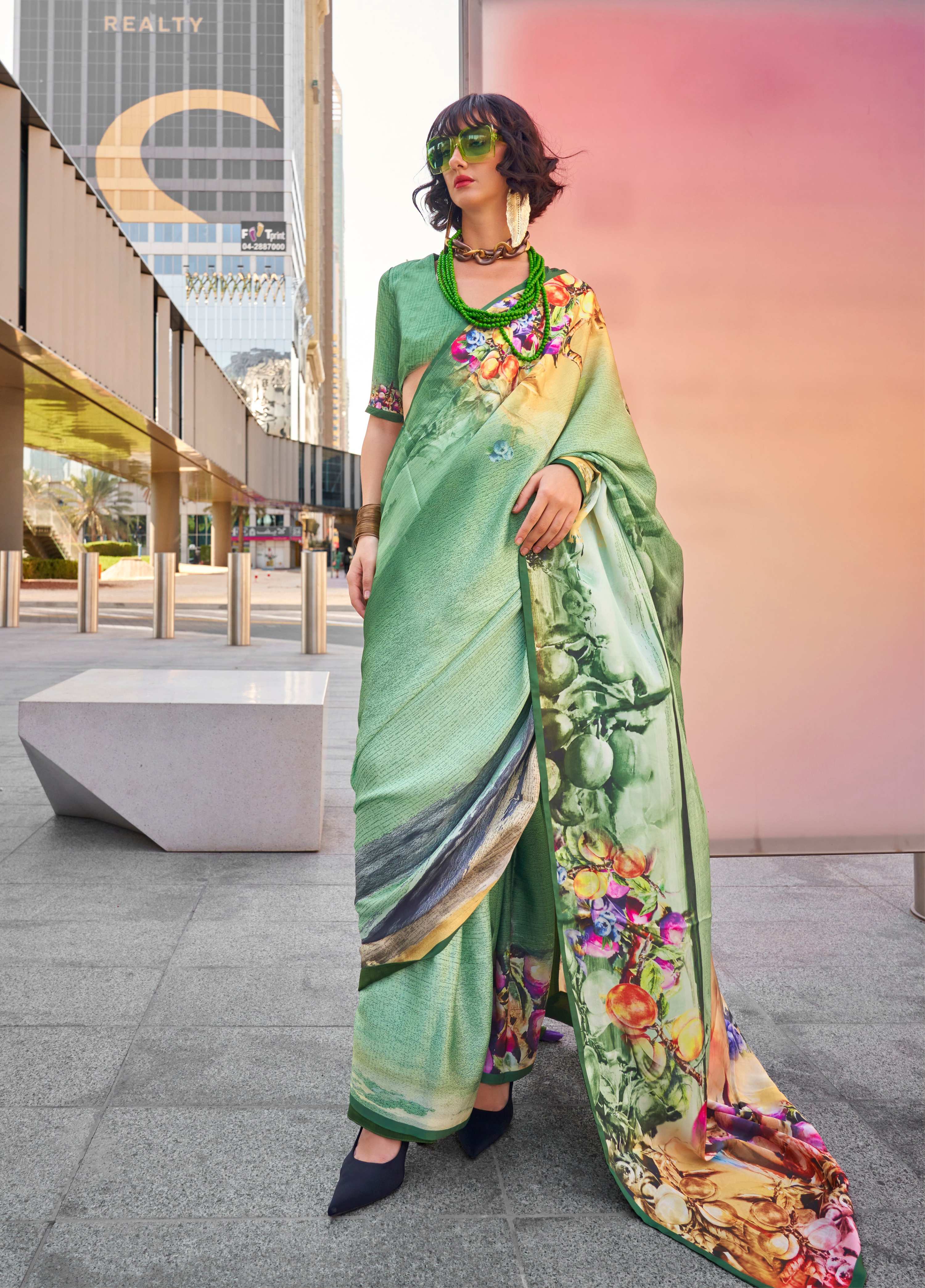 Sea green Swiss satin saree with delicate prints, styled with a matching blouse.