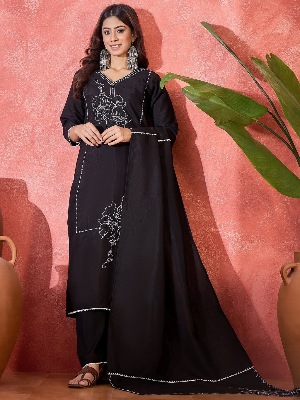 Woman wearing a black silk kurta set with detailed embroidery