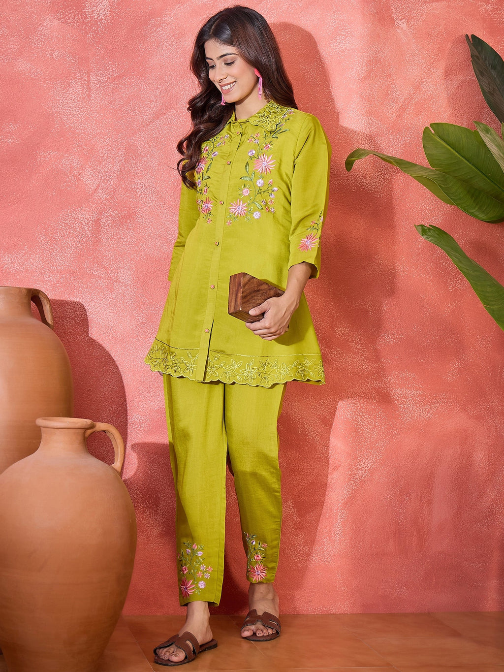 Woman wearing a green silk kaftan-style kurta set with intricate embroidery detailing