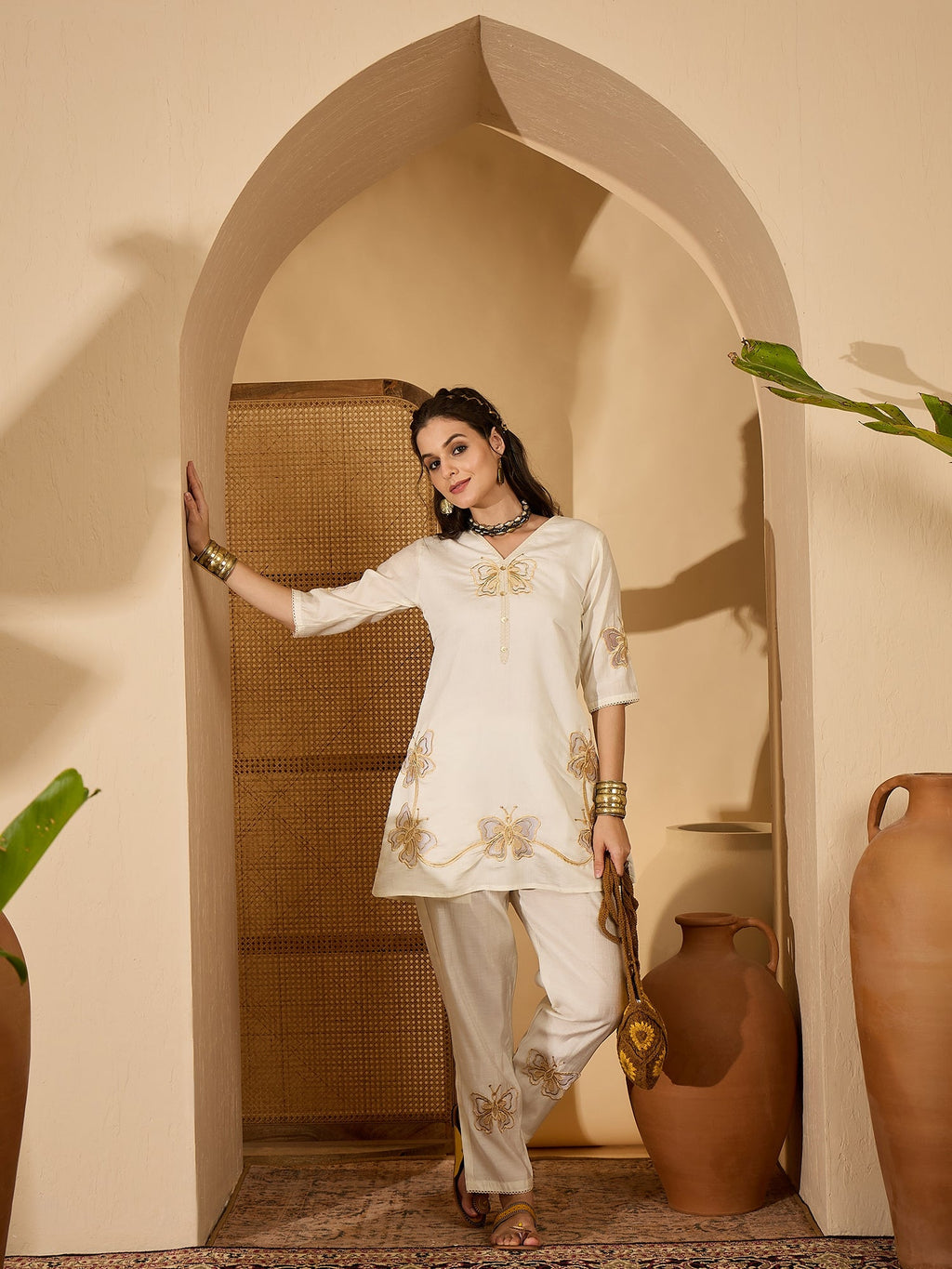 Model wearing an Off White silk embroidered kaftan style kurta set