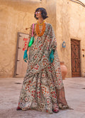 Model wearing a light grey tissue saree with floral prints