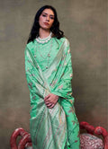 Sea green mulmul cotton saree featuring delicate floral prints.