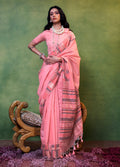 A woman wearing a Rose Pink handloom cotton saree featuring intricate weave textures.