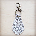 Sandy white floral embossed leather keychain with rustic antique metal clip.