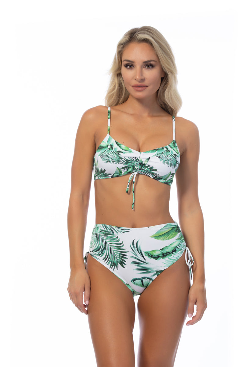 Model wearing a tropical leaf print bikini set with ruched lace-up details and high-waisted bottoms.