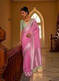 Rose pink nylon silk saree with intricate zari weaving details.