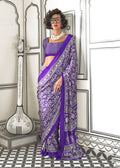 Woman wearing a royal blue satin crepe saree with abstract print patterns