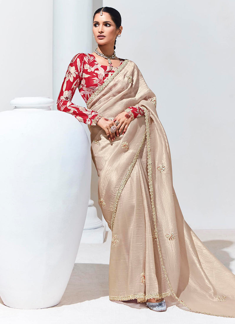 Elegant cream saree embellished with shimmering sequence embroidery for festive wear.