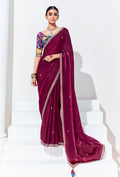 Rich plum festive saree decorated with intricate embroidery and sequence work.